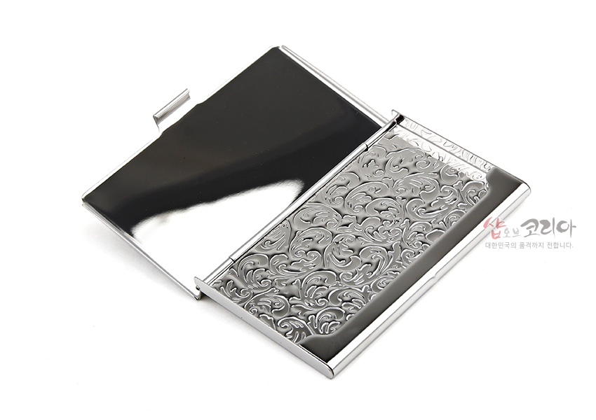 [텍스트: 샵온코리아 대한민국의 품격까지 전합니다.] 금속 재질 은색 광택 바탕에 섬세한 양각 초화문이 빽빽이 장식된 슬림 명함집 디자인