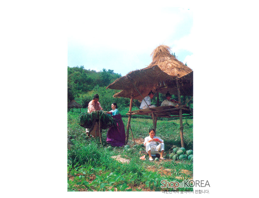 [텍스트: Shop of KOREA 대한민국 우수 공예품] 초가 원두막 아래 전통 한복 차림 인물과 수박밭 여름 농경 풍경을 담은 사진 엽서 디자인