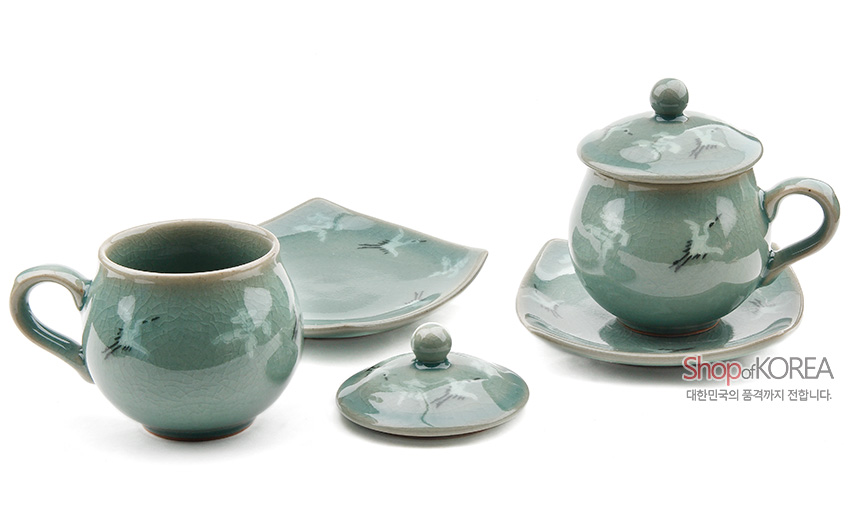 [텍스트: Shop of KOREA 대한민국의 품격까지 전합니다.] 비색 유약을 입힌 청자 찻잔과 사각 받침, 운학 문양이 상감된 2인 세트 구성