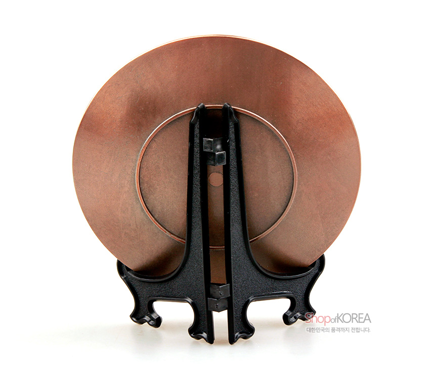 [텍스트: ShopofKOREA 대한민국의 품격까지 전합니다.] 은은한 갈색 메탈 질감의 원형 주석 장식판 뒷면과 곡선미 있는 검은색 플라스틱 받침대 모습의 이미지 표현