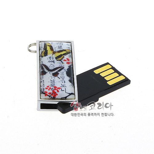 [텍스트: 샵오브코리아 대한민국의 품격까지 전합니다.] 금속 프레임 사각 USB 본체 위 한글 서체 배경에 노랑·검정 나비와 붉은 매화문, 흰 바탕의 인쇄 장식 디자인