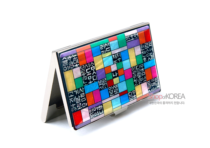 [텍스트: Shop of KOREA 대한민국의 품격까지 전합니다.] 금속 재질 위 자개와 옻칠로 표현된 다채로운 조각보 패턴과 흰색 훈민정음 글자 음각 장식 명함집 디자인