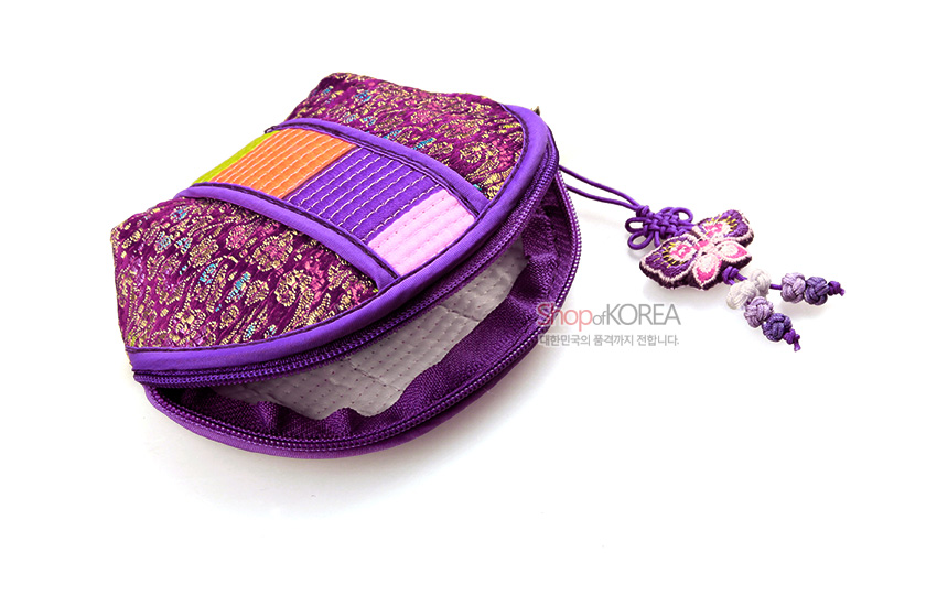 [텍스트: ShopofKOREA 대한민국의 품격까지 전합니다.] 보라색 누비 비단과 금색 꽃문양, 전면 색동띠 장식, 지퍼 여밈과 나비 매듭 술 장식 동전지갑 디자인
