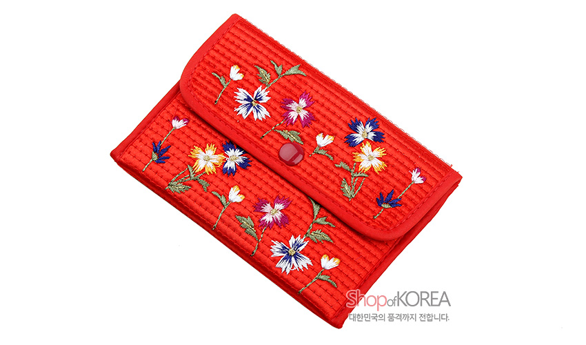 [텍스트: Shop of KOREA, 대한민국의 품격까지 전합니다.] 선명한 적색 누비 천 위에 다채로운 실로 꽃문양 자수를 놓고 똑딱이 단추를 더한 직사각형 동전지갑 디자인