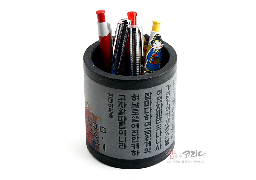 [텍스트: 나랏말싸미 듕귁에 달아... 현대어풀이] 원통형 종이 펜꽂이에 훈민정음 서체와 세종대왕 일러스트가 인쇄된 흑회색 전통 디자인 소품