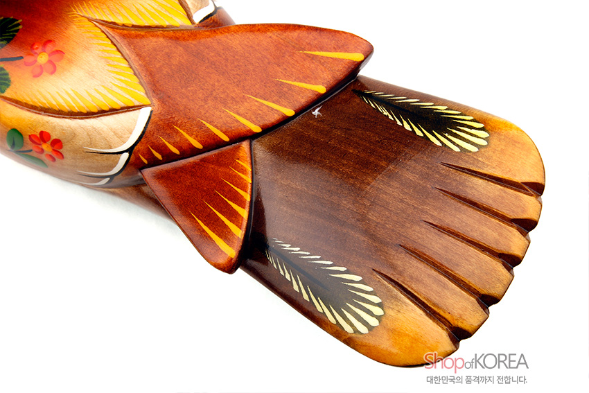 [텍스트: ShopofKOREA 대한민국의 품격까지 전합니다.] 나무 재질에 붉은·갈색 그라데이션 채색으로 깃털과 꼬리선을 표현하고, 노랑·초록 꽃무늬를 더한 원앙 목각 장식 디테일 이미지