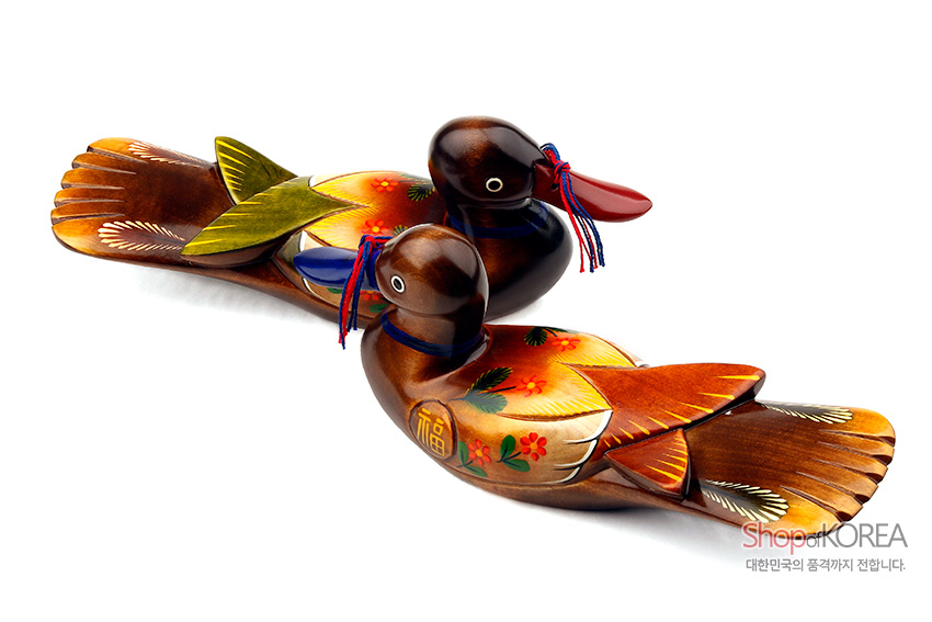 [텍스트: 福] 원목 재질 위 붉은·노랑·초록 채색으로 꽃과 복자 문양을 더한 원앙 한 쌍과 청·홍색 끈 장식 모습