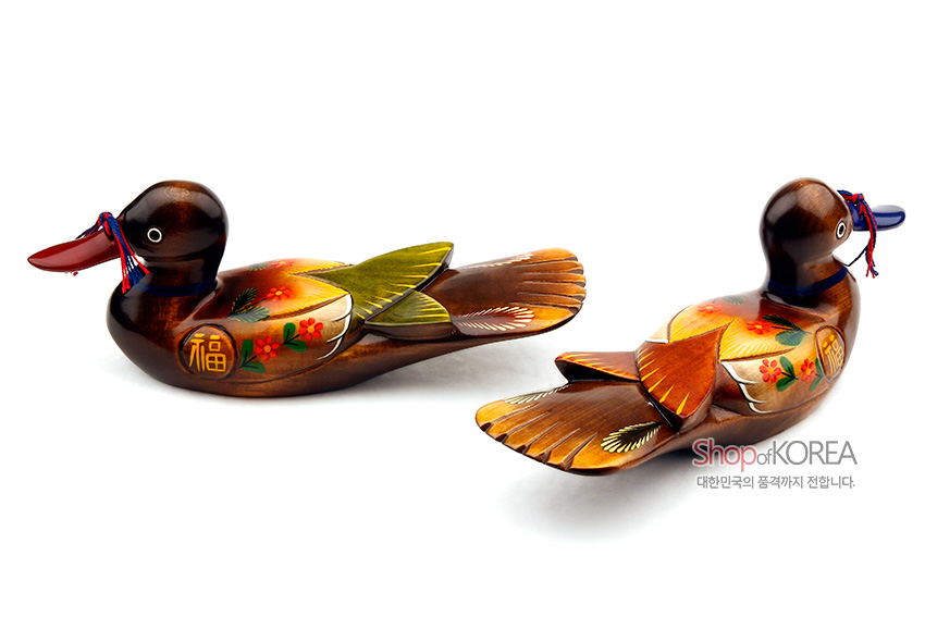 [텍스트: 福, Shop of KOREA, 대한민국의 품격까지 전합니다.] 나무 재질에 붉은·노랑·초록 채색으로 꽃과 복(福)자 문양을 그린 원앙 한 쌍과 청홍색 매듭 장식의 목각 장식품
