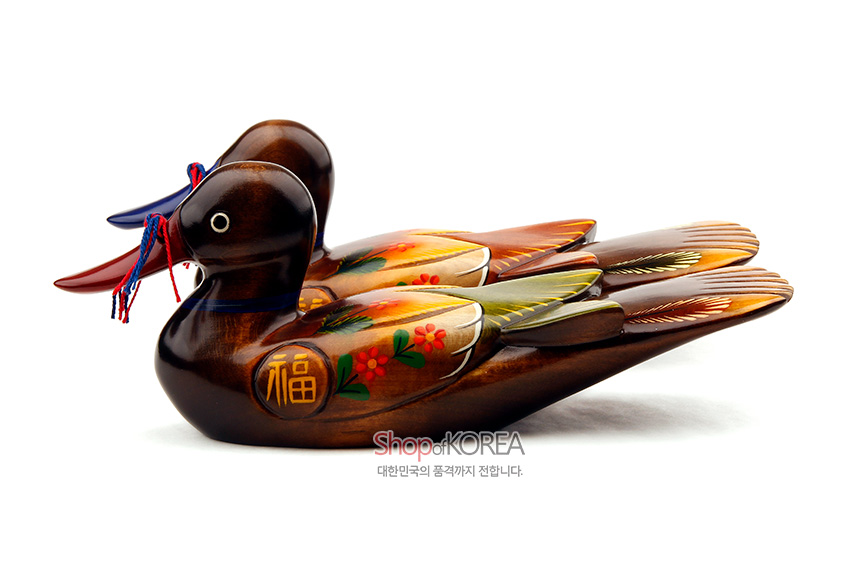 [텍스트: 福, ShopofKOREA, 대한민국의 품격까지 전합니다.] 나무를 조각해 갈색 바탕에 붉은·노랑·초록 채색으로 꽃과 복자 문양을 그린 원앙 한 쌍, 청·홍색 매듭 끈 장식의 목각 장식품