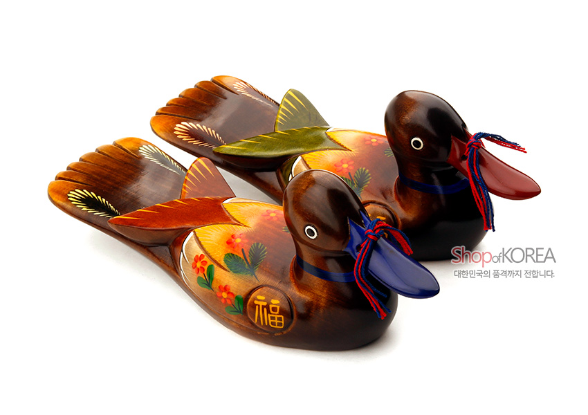 [텍스트: 福, Shop of KOREA, 대한민국의 품격까지 전합니다.] 나무 재질 위 붉은·노랑·초록 채색과 꽃·복자 문양, 청홍 매듭 끈으로 장식된 원앙 한 쌍 목각 장식