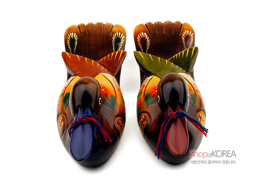 [텍스트: Shop of KOREA 대한민국의 품격까지 전합니다.] 나무 재질에 채색 기법으로 표현된 원앙 한 쌍, 꽃과 복자 문양, 청·홍색 끈 장식이 돋보이는 목각 장식품