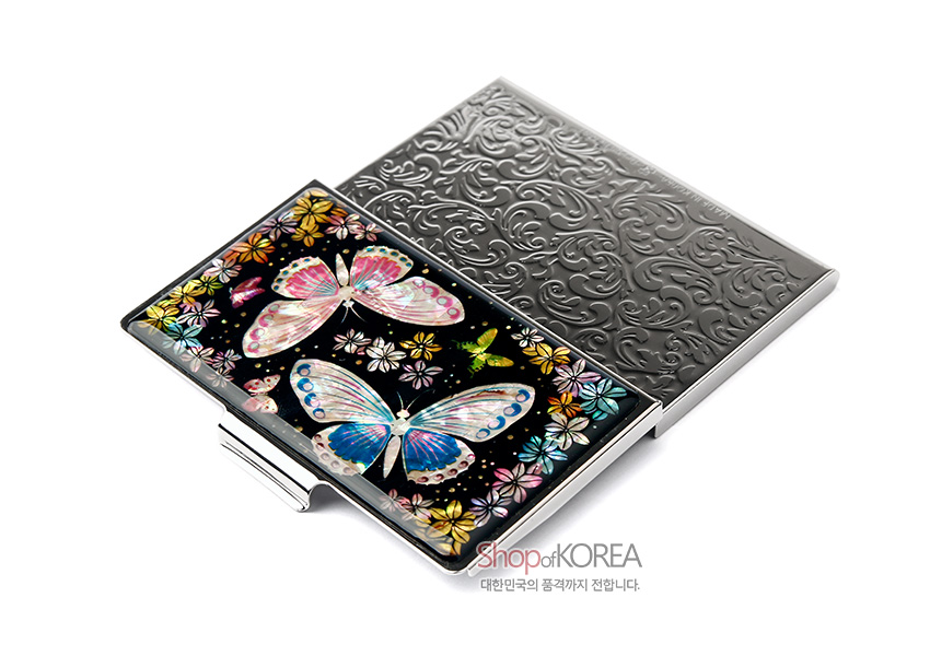[텍스트: Shop of KOREA 대한민국의 품격까지 전합니다.] 흑색 바탕 위 화려한 자개 상감 나비와 꽃문양, 금속 양각 무늬 뚜껑이 조화를 이룬 명함케이스 이미지설명