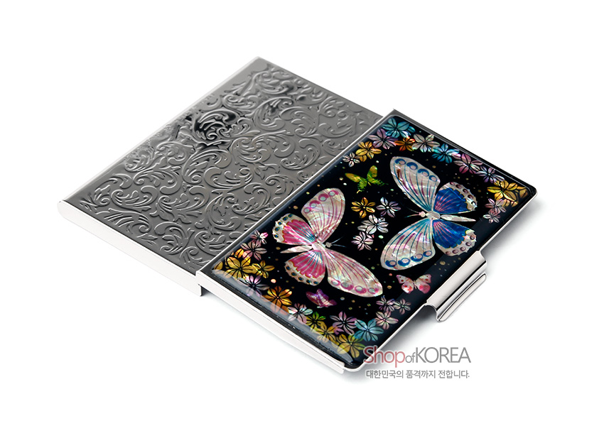 [텍스트: Shop of KOREA 대한민국의 품격까지 전합니다.] 흑색 배경 위 천연 자개 상감 기법으로 표현된 다채로운 나비와 꽃문양, 메탈릭 양각 문양이 조화를 이룬 금속 명함케이스 이미지설명