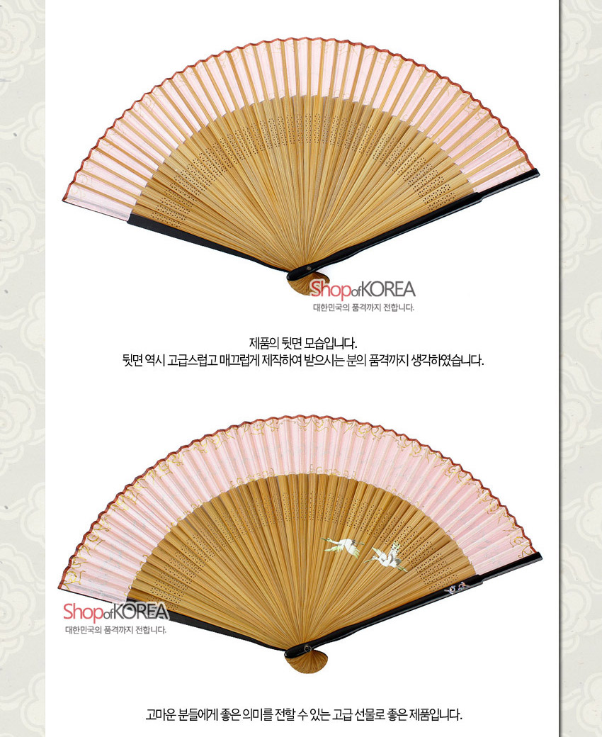 [텍스트: ShopofKOREA 대한민국의 품격까지 전합니다. 제품의 뒷면 모습입니다. 뒷면 역시 고급스럽고 매끄럽게 제작하여 받으시는 분이 품격까지 생각하였습니다. ShopofKOREA 대한민국의 품격까지 전합니다. 고마운 분들에게 좋은 의미를 전할 수 있는 고급 선물로 좋은 제품입니다.] 연분홍 실크 천과 대나무살, 섬세한 타공 기법, 가장자리 금색 물결 문양과 학 자수 장식 부채 모습