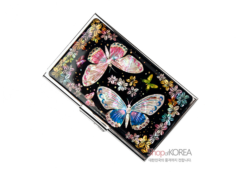 [텍스트: shopofKOREA 대한민국의 품격까지 전합니다.] 흑색 바탕 위 자개 상감 기법으로 표현된 다채로운 나비와 화려한 꽃문양이 어우러진 금속 명함케이스 디자인