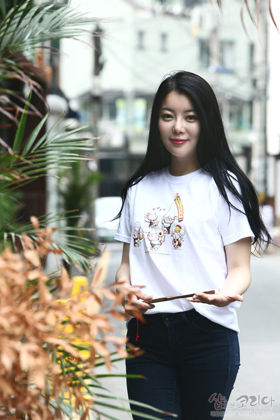 [텍스트: 샵오브코리아 대한민국 전통자개 공예품 쇼핑몰] 순면 흰색 반팔 티셔츠 위 풍물놀이 인물과 악기를 그린 다색 3D 입체발포 인쇄 문양, 경쾌한 전통 장단 표현 디자인