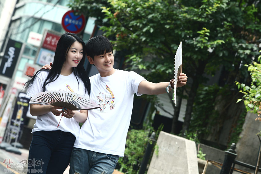 [텍스트: 샵오브코리아] 흰색 순면 반팔 티셔츠에 풍물놀이 장단을 그린 다색 3D 입체발포 전통문양 프린트가 돋보이는 캐주얼 거리 연출 이미지