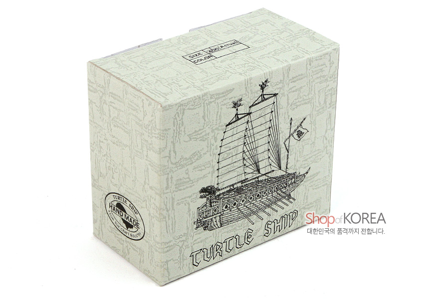 [텍스트: TURTLE SHIP, HAND MADE, Shop of KOREA 대한민국의 품격까지 전합니다.] 연한 회색 바탕에 거북선 선체와 돛을 흑백 선묘로 표현한 종이 패키지 디자인