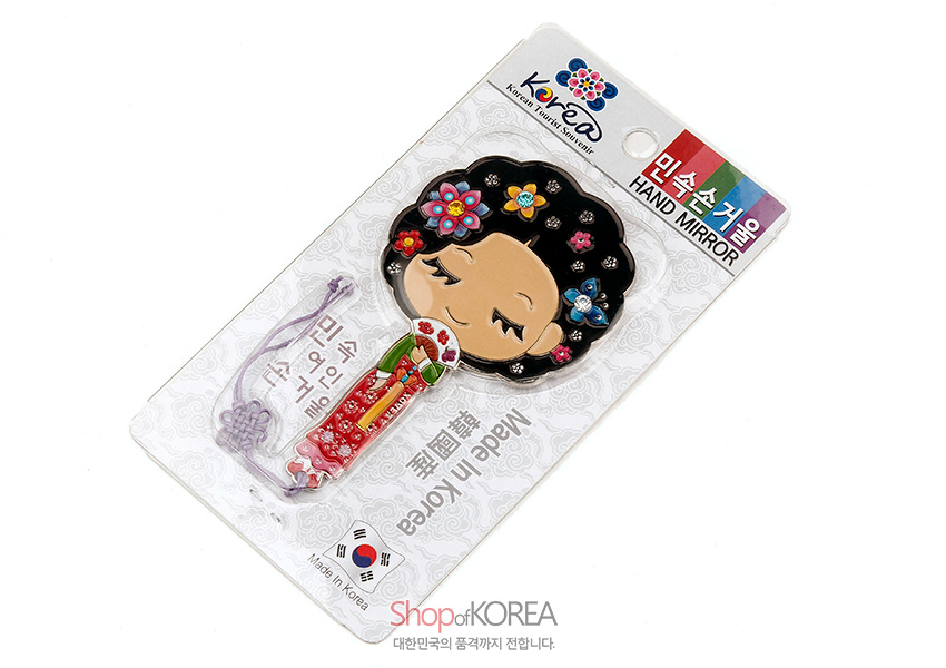 [텍스트: 민속손거울, HAND MIRROR, Made in Korea] 금속 재질에 채색 기법으로 표현한 한복 차림 황진이 캐릭터와 다채로운 꽃 문양, 보라색 전통 매듭 끈 장식의 손거울 이미지