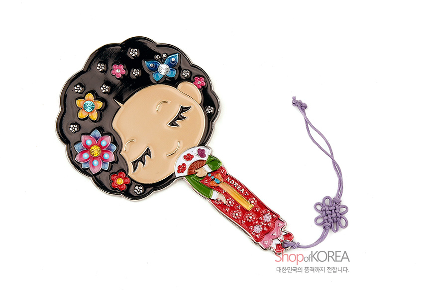 [텍스트: KOREA] 금속 재질 위 채색 기법으로 표현된 황진이 캐릭터와 꽃, 나비 문양 장식, 붉은 한복 색감과 보라색 전통 매듭 끈이 어우러진 손거울 디자인