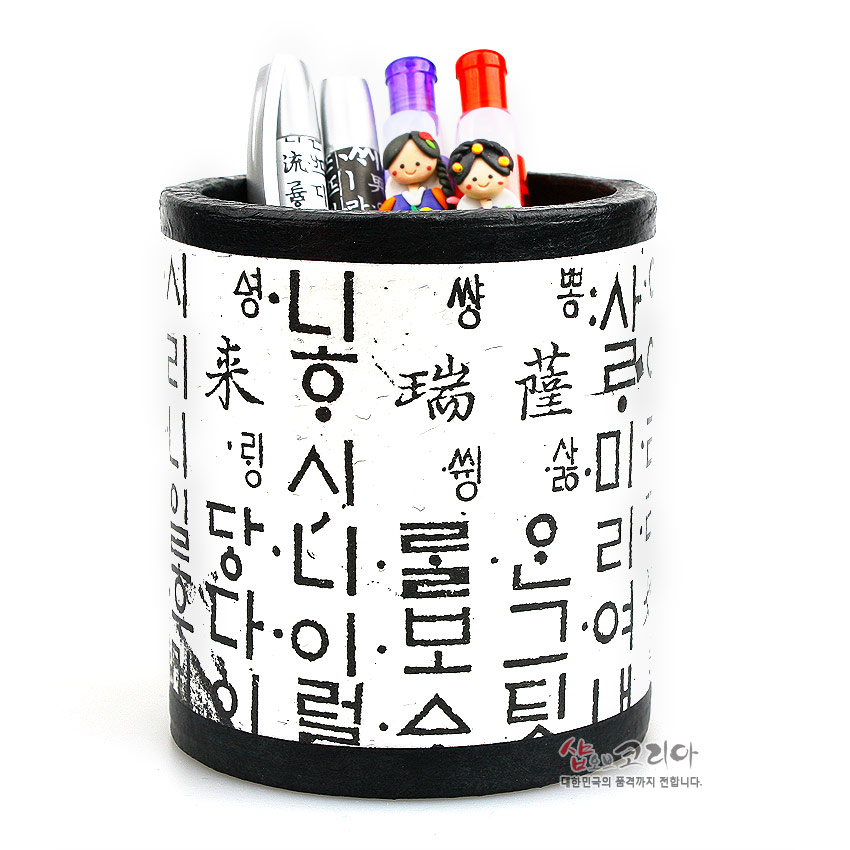 [텍스트: 닝 ㅅㅣ니이럴 …] 흰색 한지 위에 검은색 훈민정음 자모와 한자가 빼곡히 배치된 원통형 연필꽂이, 상단·하단에 검정 테두리 마감된 디자인