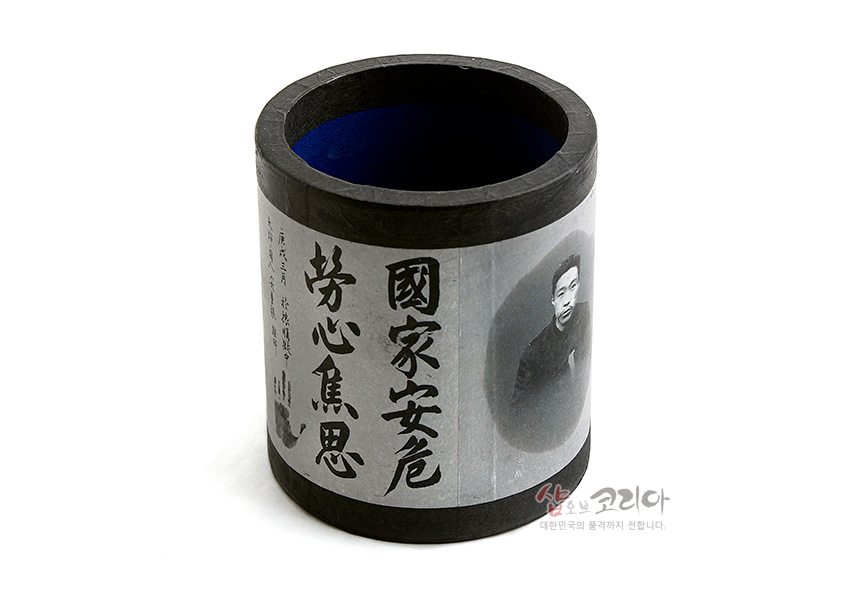 [텍스트: 國家安危 勞心焦思] 흑백 한지 감싸기 기법의 원통형 펜꽂이, 검은 테두리와 서예체 한자 및 흑백 인물 사진이 어우러진 디자인