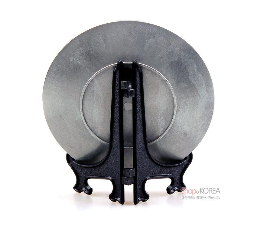 [텍스트: ShopofKOREA 대한민국의 품격까지 전합니다.] 무광 은회색 주석 원형 장식패와 검정 색상의 곡선형 플라스틱 거치대의 후면 모습 표현