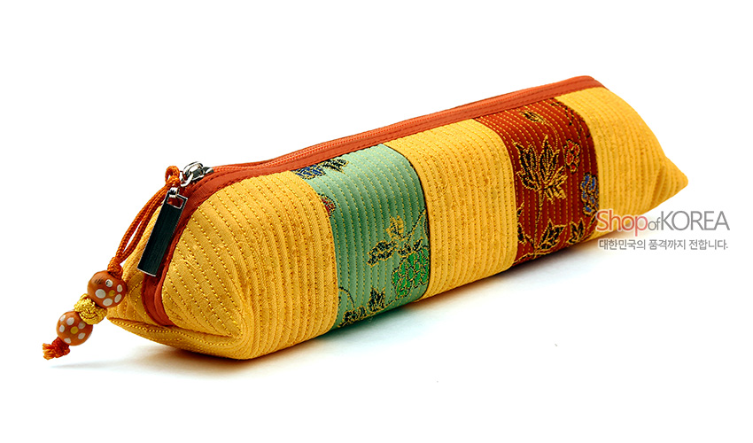 [텍스트: Shop of KOREA 대한민국의 품격까지 전합니다.] 노란색 누비 원단과 초록·적색 비단 패치가 조합된 원통형 필통, 단풍·꽃문양 직조와 주황 지퍼, 구슬 장식 매듭 디테일의 디자인