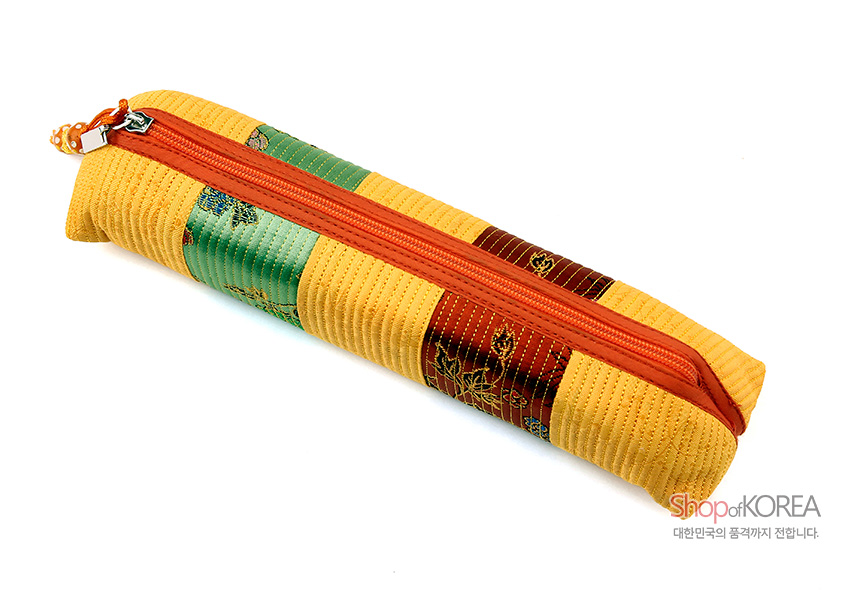 [텍스트: Shop of KOREA 대한민국의 품격까지 전합니다.] 황색 누비 원단과 초록·갈색 비단 패치, 꽃문양 자수 장식, 주황색 지퍼가 조화를 이룬 직사각형 필통 디자인