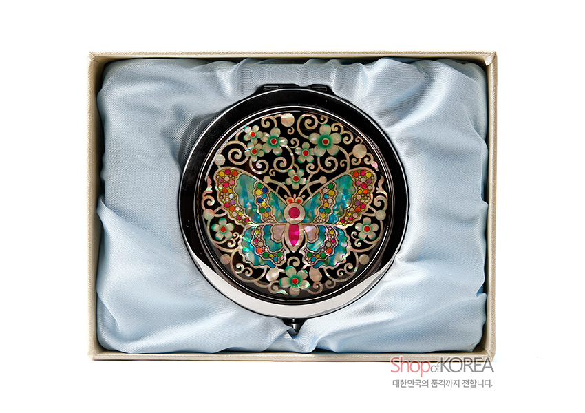 [텍스트: ShopofKOREA 대한민국의 품격까지 전합니다.] 흑색 바탕 위 금속 원형 거울, 천연 자개 상감 채색 나비와 꽃·덩굴 문양, 은은한 오팔빛 색채 대비 연출