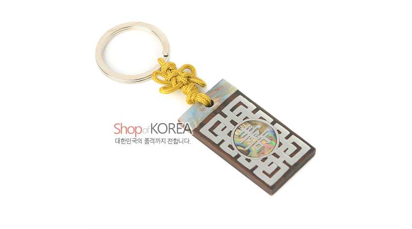 [텍스트: Shop of KOREA / 대한민국의 품격까지 전합니다.] 흑단 바탕에 자개 상감된 수문과 기하학 문양 장식, 상단 자개 띠와 노란 전통 매듭, 금속 고리 결합 열쇠고리 디자인