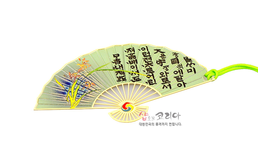 [텍스트: 흥❍❍예닿아 / 고운향기와듯서 / 이몸둘둘목메어져서 / 절배이루오리] 금속 재질 부채형 책갈피에 연두색 바탕, 훈민정음 서체와 난초 문양, 24K 골드 테두리와 연두색 매듭 끈 조화 이미지 설명
