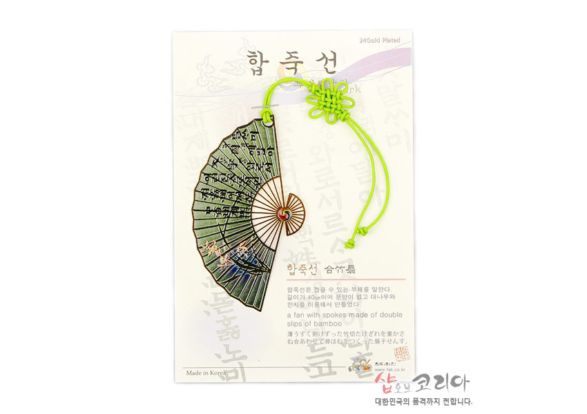 [텍스트: 합죽선, 24Gold Plated, Made in Korea 등] 금속 부채형 책갈피에 녹색 바탕과 난초 문양, 훈민정음 글자 표현, 형광 연두색 전통 매듭 끈 장식 구성