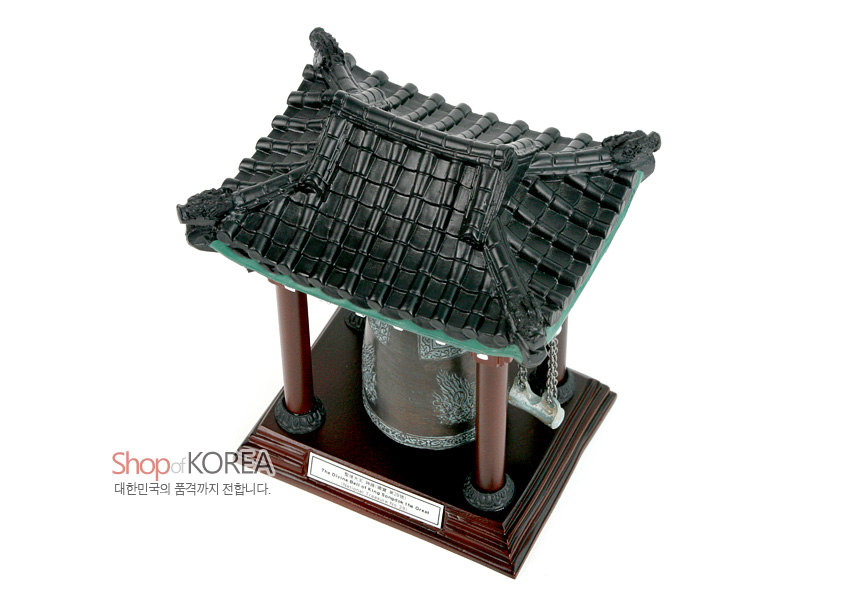 [텍스트: Shop of KOREA 대한민국의 품격까지 전합니다.] 청동색 범종과 목조 기둥, 검은 기와지붕이 조합된 합성수지 종각 모형, 용무늬와 기와 패턴을 섬세하게 표현한 장식품