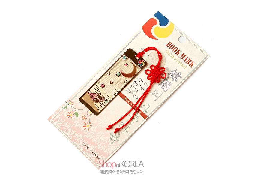 [텍스트: BOOK MARK, Gold plated, Special, Shop of KOREA, MADE IN KOREA] 금장 금속 책갈피에 달과 별, 고동 문양 양각 장식과 붉은 전통 매듭 끈이 어우러진 디자인