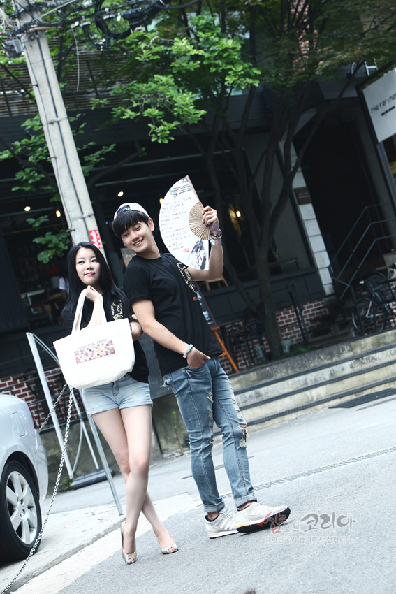 [텍스트: 샵오브코리아] 검정색 면 티셔츠에 금색 입체발포 호랑이 문양이 새겨진 캐주얼 거리 패션 연출 이미지