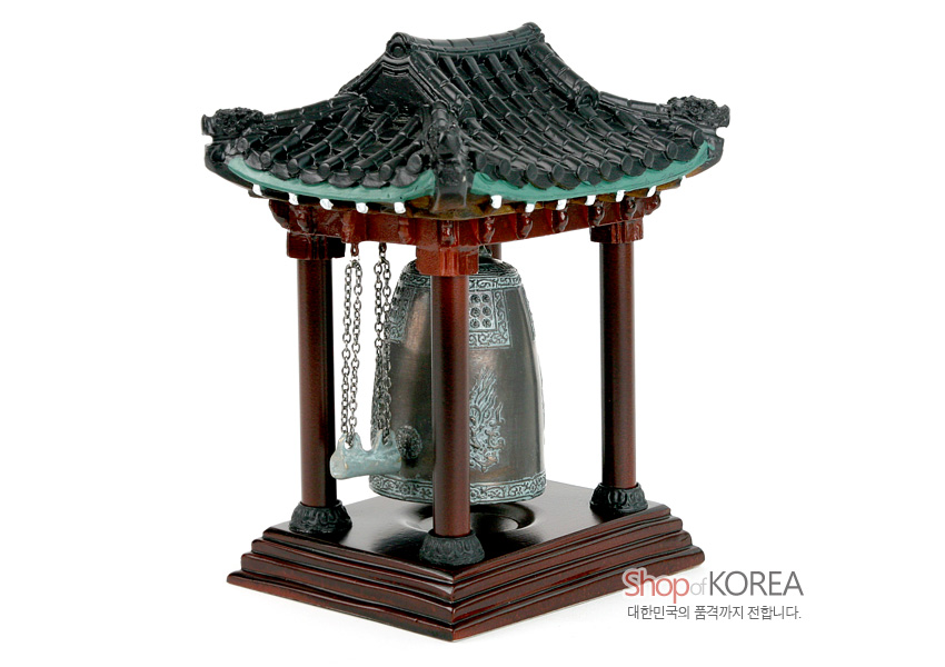 [텍스트: Shop of KOREA 대한민국의 품격까지 전합니다.] 청동 색감의 전통 동종 모형과 목재 느낌의 누각, 검은 기와지붕과 용두 장식, 세밀한 문양 표현의 합성수지 공예품 모습