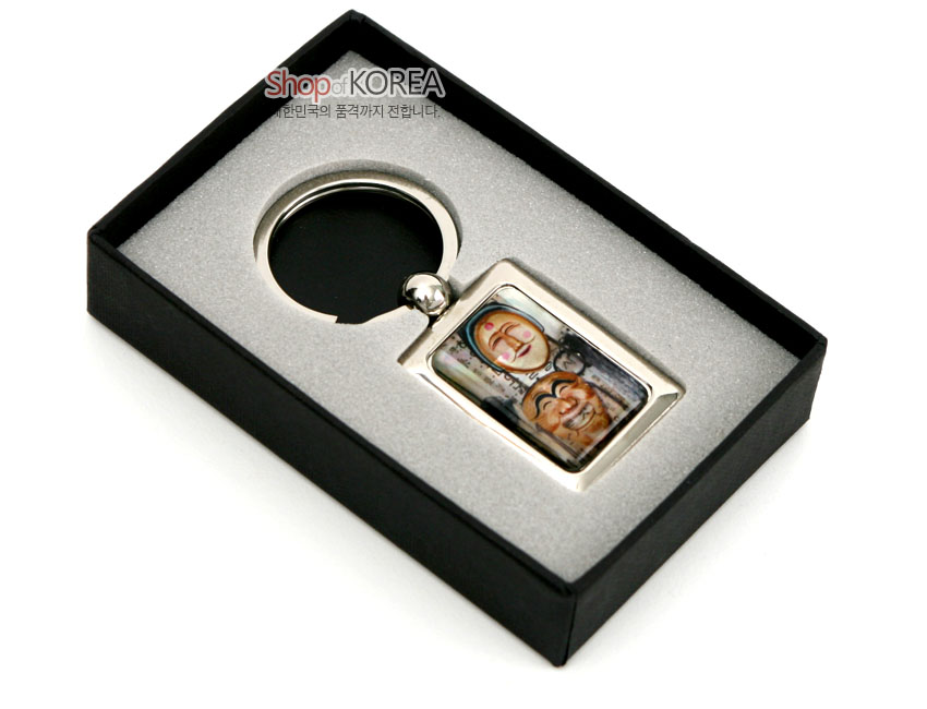 [텍스트: Shop of KOREA 대한민국의 품격까지 전합니다.] 금속 프레임 안 자개 상감 기법으로 양반탈과 부네탈을 다채로운 색감으로 표현한 사각 열쇠고리 디자인