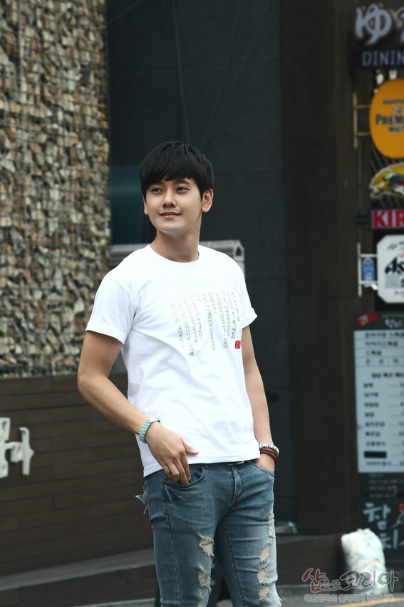 [텍스트: 훈민정음 해례본 서문 일부 한글·한자 혼용 문구] 흰색 면 티셔츠 위 금빛 입체발포 훈민정음 서체와 붉은 전각 문양이 어우러진 디자인