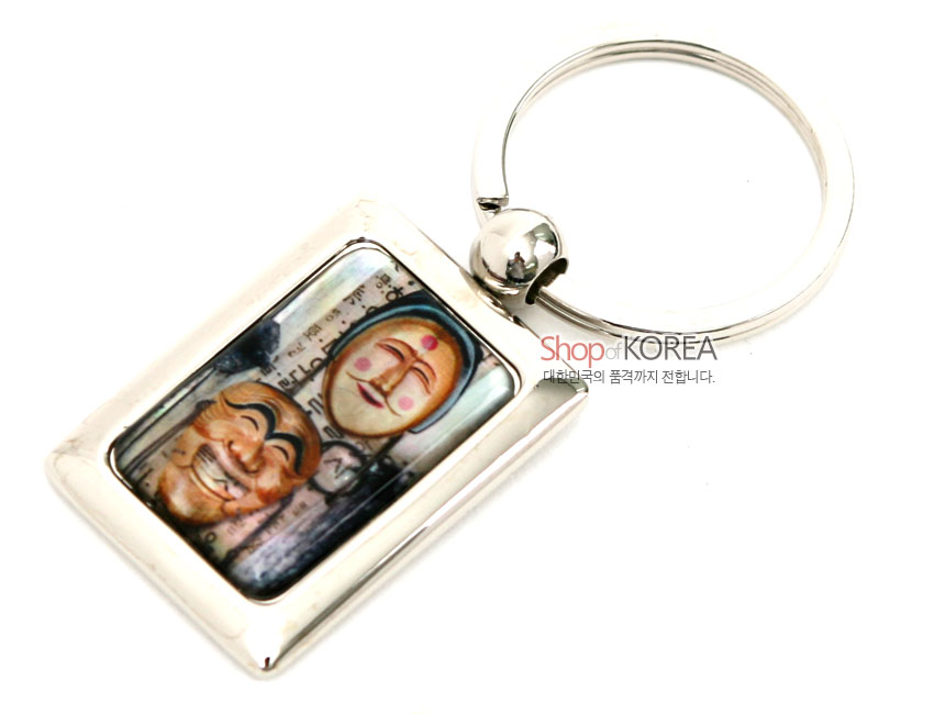 [텍스트: Shop of KOREA, 대한민국의 품격까지 전합니다.] 금속 사각 프레임에 자개 상감 기법으로 양반탈과 각시탈을 채색 표현한 열쇠고리 디자인