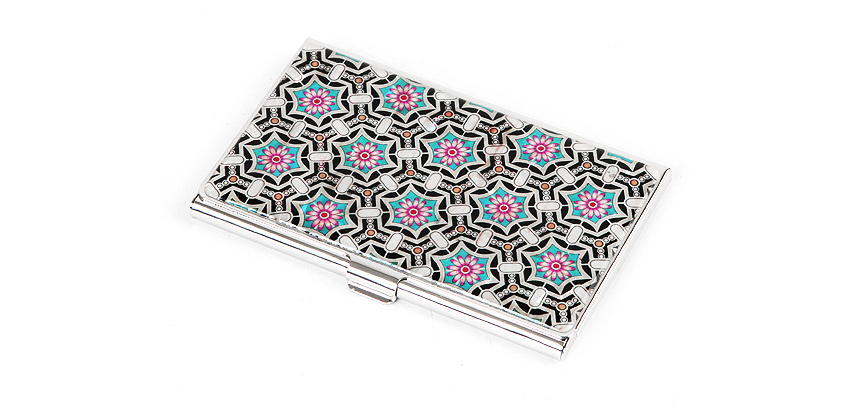 은색 금속 케이스 위 흑색 바탕에 분홍·청록색 자개 꽃단청 문양을 반복 상감한 기하학 패턴 명함집 모습