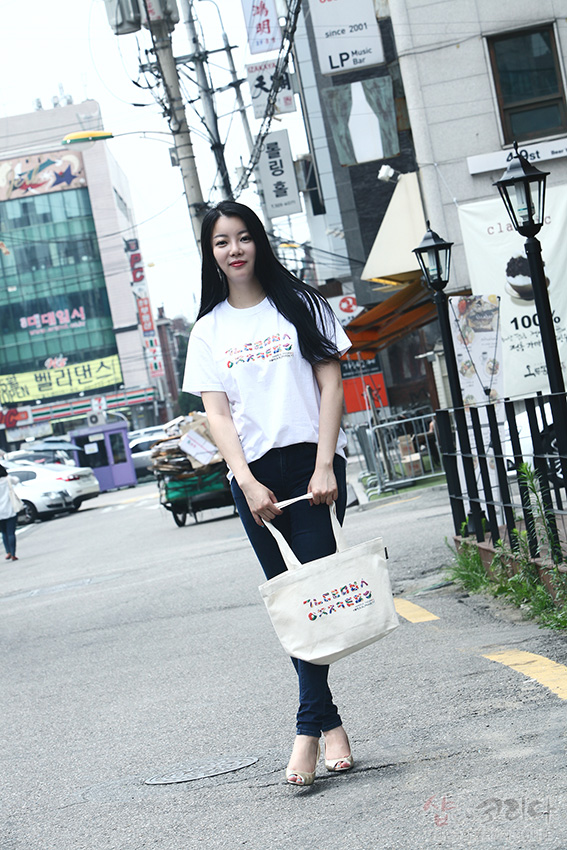 [텍스트: 가 ㄴ ㄷ 모던한 한글 가방] 아이보리 캔버스 소재 토트백에 다채로운 색상의 한글 자모를 입체발포 기법으로 배치한 디자인으로 경쾌한 거리감 연출