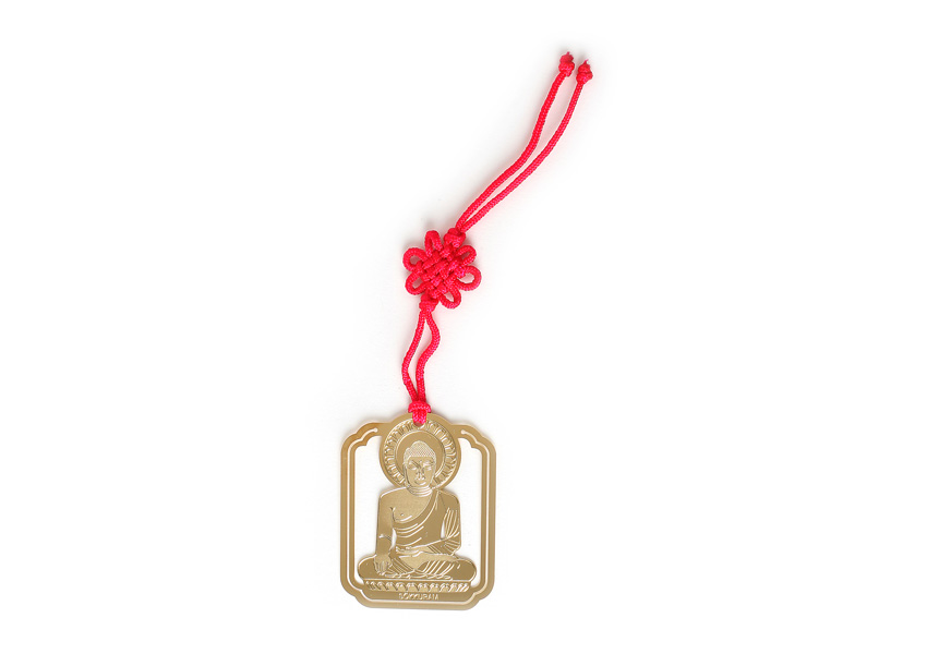 [텍스트: 불상 하단 영문 각인] 금속 재질 금장판에 석굴암 본존불을 정교하게 양각하고, 붉은색 전통 매듭 끈을 더한 직사각형 책갈피 디자인