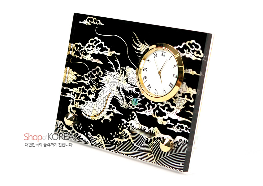 [텍스트: Shop of KOREA, 대한민국의 품격까지 전합니다.] 검은 옻칠 바탕에 자개 상감으로 용·구름·파도 문양을 넣고 금색 메탈 테두리 원형 시계를 결합한 탁상용 시계 디자인