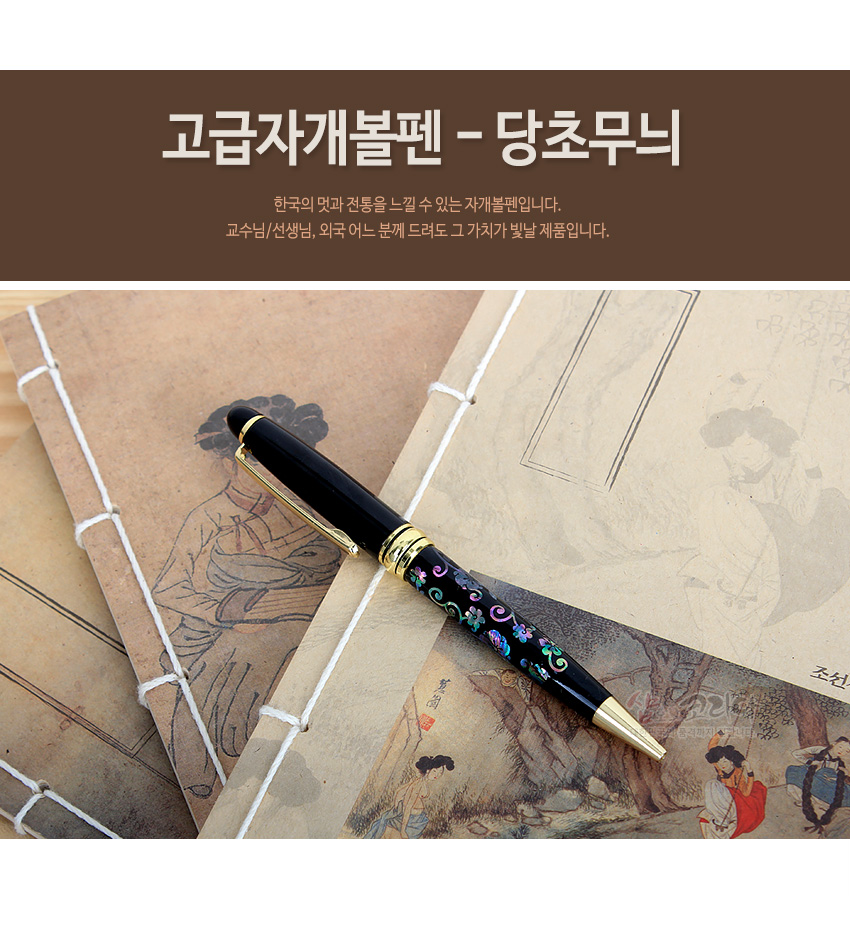 [텍스트: 고급자개볼펜 - 당초무늬 / 한국의 멋과 전통을 느낄 수 있는 자개볼펜입니다. 교수님/선생님, 외국 어느 분께 드려도 그 가치가 빛날 제품입니다.] 검은 옻칠 바탕 위 오색 자개 상감 당초무늬와 금색 금속 장식이 조화를 이룬 볼펜 이미지 설명