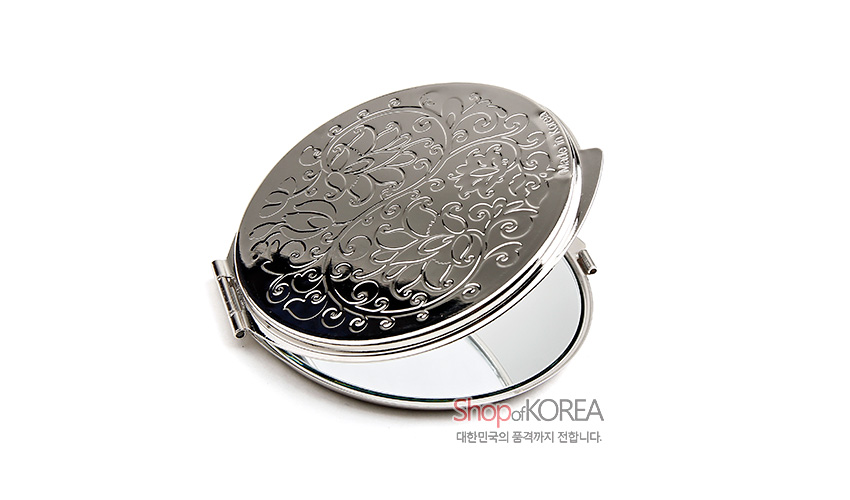 [텍스트: Shop of KOREA / 대한민국의 품격까지 전합니다.] 금속 재질 원형 손거울, 상단에 연꽃과 덩굴문 상감한 양각 장식, 은색 광택 마감 디자인