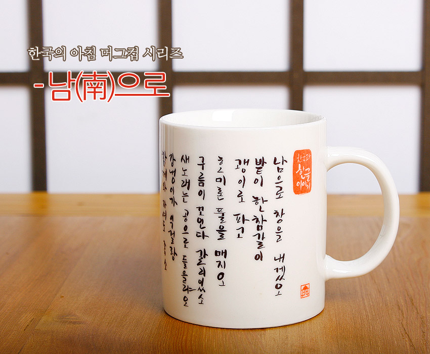 [텍스트: 한국의 아침 머그컵 시리즈 - 남(南)으로 / 남으로 창을 내겠소…] 백자 느낌의 흰색 도자 머그컵에 세로 한글 서예와 붉은 전각 인장이 대비되는 전통 서체 장식 이미지