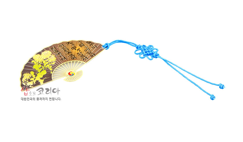 [텍스트: 사람마다 그 품격이 다르다. / shop of korea 대한민국의 품격까지 전합니다.] 금속 재질 부채형 책갈피에 황금빛 국화와 훈민정음 글귀 장식, 청색 전통 매듭 끈 포인트 디자인