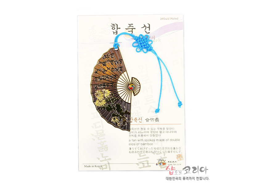 [텍스트: 합죽선, Made in Korea] 24k 도금 금속 부채형 책갈피에 국화 문양과 훈민정음 글자 새김, 중앙 태극 문양 장식, 하늘색 전통 매듭끈 포인트 디자인
