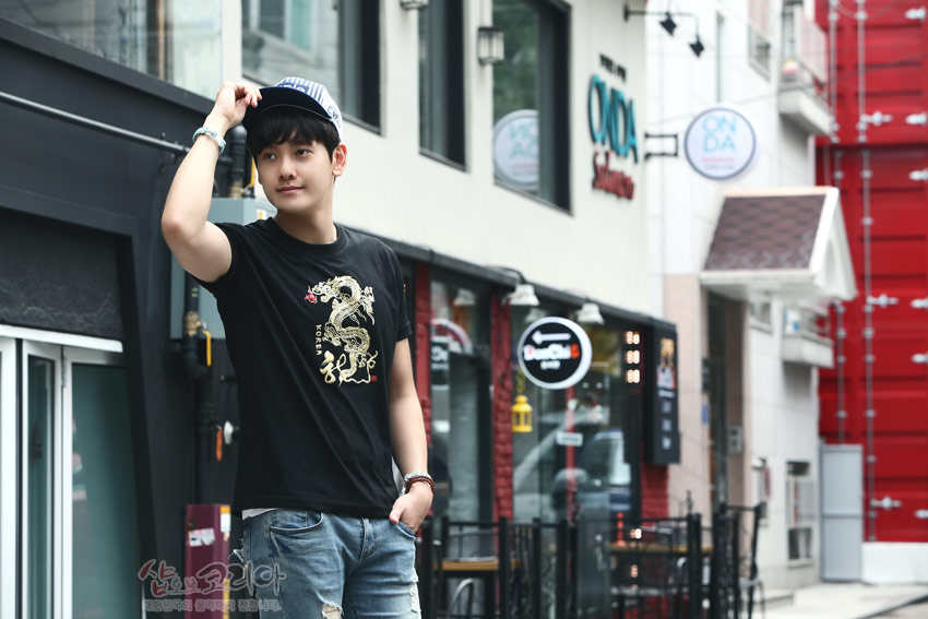 [텍스트: KOREA] 검은 면 티셔츠 중앙 금색·붉은색 입체발포 기법 용 문양, 곡선 미늘과 불꽃 디테일이 돋보이는 전통무늬 디자인